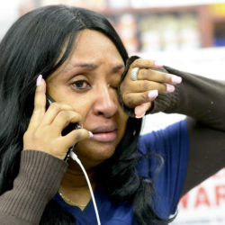 Martene Bonny, a medical aide, cries after barely getting out of burning medical clinic.
