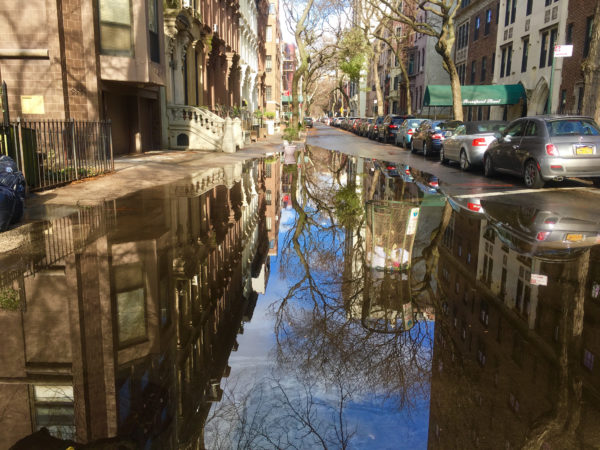 A mammoth puddle mirrors a cluster of rowhouses that includes recently sold 218 Columbia Heights. Eagle photo by Lore Croghan 
