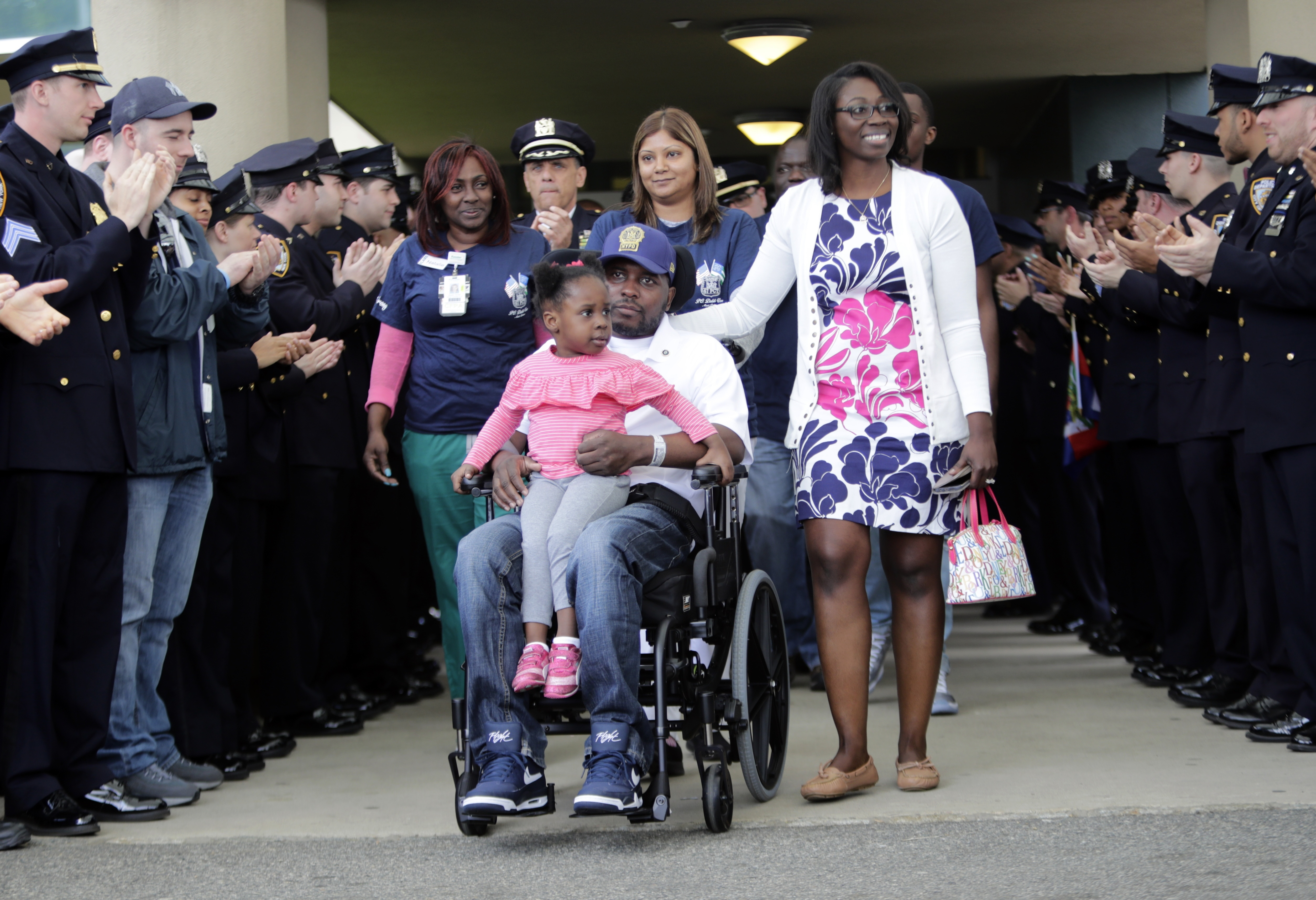 New York Police Detective Dalsh Veve (center) leaves the Kessler Institute for Rehabilitation with his wife, Esther (right) and daughter Dashi on May 7 in West Orange, New Jersey. Veve was critically injured in June 2017 when he was dragged by a driver in a stolen car. AP Photo/Frank Franklin II
