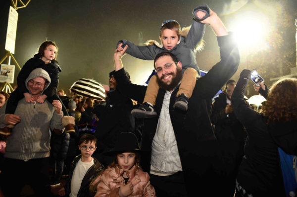 Thousands of area residents attended the lighting of the Hanukkah menorah at Grand Army Plaza, lit by Mayor Bill de Blasio. Families get together for the lighting of the Menorah, despite the rain.