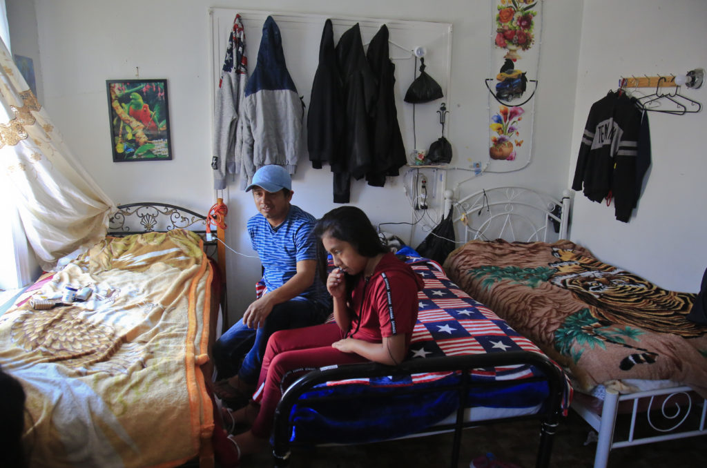 Manuela Marcelino, 11, left, sits with her father Manuel Marcelino Tzah inside their apartment hours after her release from immigrant detention, Wednesday July 18, 2018, in Brooklyn borough of New York. The Guatemalan asylum seekers were separated May 15 after they crossed the U.S. border in Texas. (AP Photo/Bebeto Matthews)