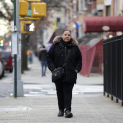 In a photo taken Sunday, Dec. 23, 2018, Flavia Cabral walks to her mother's home in the Bronx section of New York. Cabral, who works two jobs, will be among many people benefiting from the minimum wage raise which will hit $15 on Dec. 31st. (AP Photo/Julio Cortez)