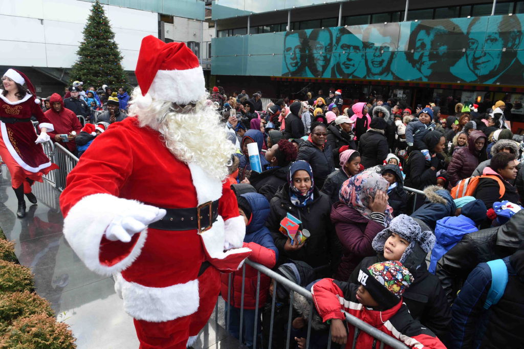 Mr. and Mrs. Santa Claus bring cheer and gifts to thousands of kids at Restoration Plaza on Fulton Street. Eagle photos by Todd Maisel