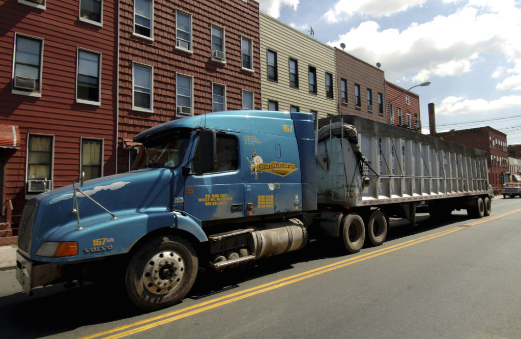 A privately owned sanitation truck drives down Metropolitan Ave. in the Greenpoint section of Brooklyn, New York, (AP Photo/Henny Ray Abrams)