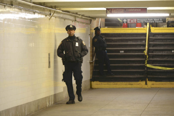 A police officer guards the crime scene in the Prospect Park train station this morning.