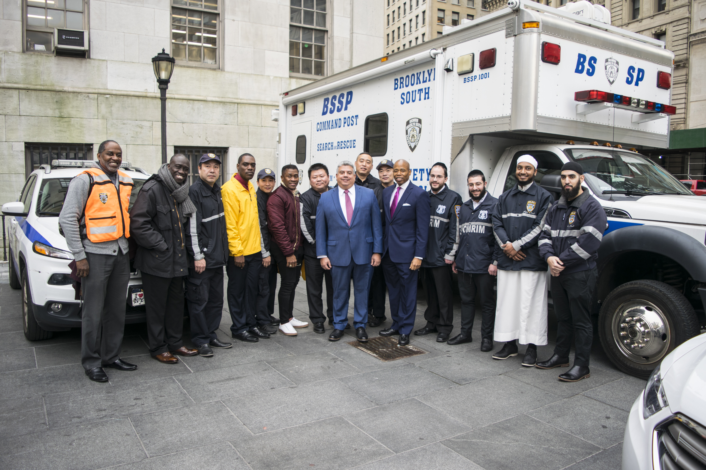 Eric Gonzalez and Eric Adams pose with some of the law enforcement officers and community organizers whom they have credited with helping to set a record-low number of homicides in Brooklyn last year. Eagle photo by Rob Abruzzese