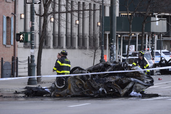 Firefighters stand next to the remains of the vehicle that Amy Phillipson was driving when it vehicle was struck, causing it to flip over on West Street in Tribeca.