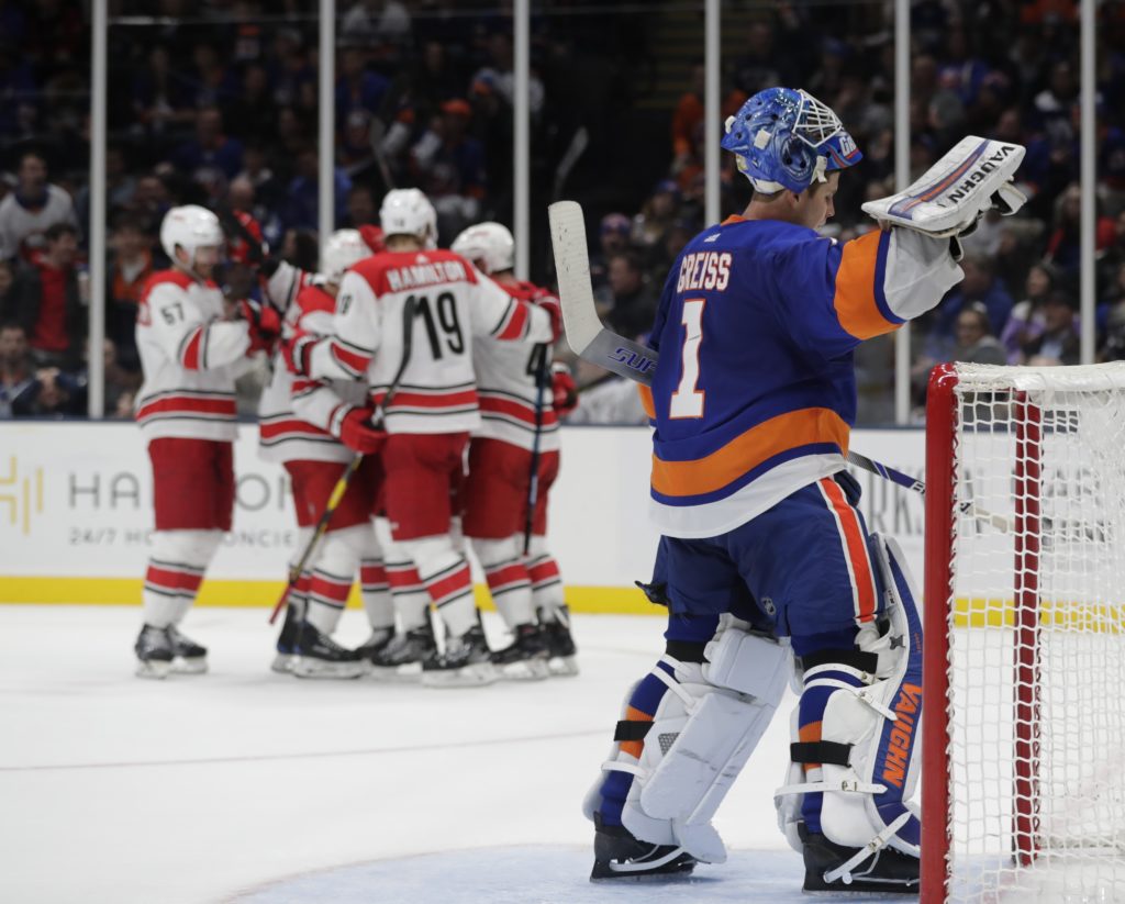 Thomas Greiss can only look on in anguish as the Carolina Hurricanes celebrate the tiebreaking goal vs. the Islanders Tuesday night at Nassau Coliseum.