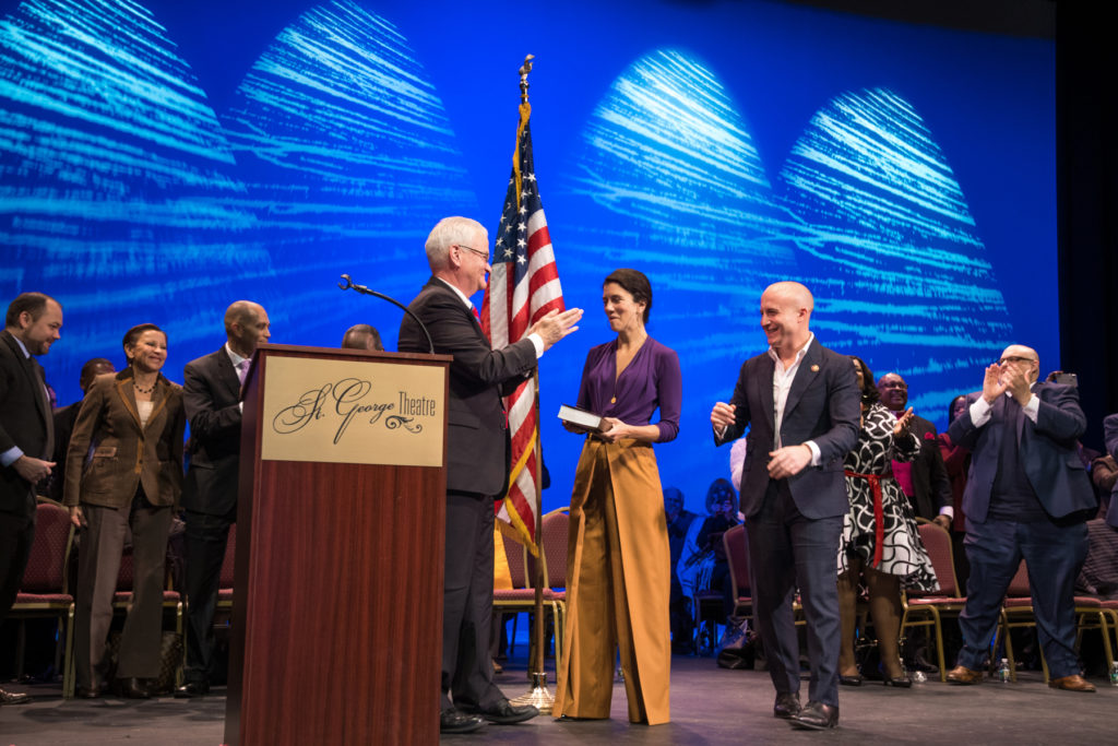 With his wife Leigh at his side, U.S. Rep. Max Rose (right) prepares to take the oath of office from Staten Island District Attorney Michael McMahon (left) at the St. George Theater. Eagle photo by Corazon Aguirre