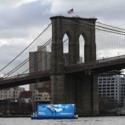A 60-foot-wide advertising barge with a 20-foot high screen, roaming the East River and New York Harbor, has created an uproar from residents and politicians. Eagle photos by Todd Maisel