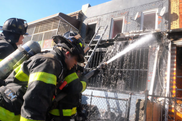 Firefighters spray water on the remnants of the blaze on Linden Boulevard. Eagle photos by Todd Maisel