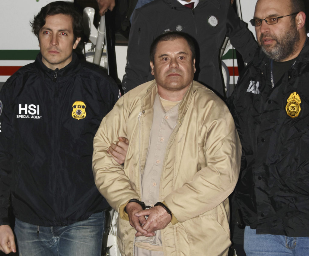 In this Jan. 19, 2017 photo provided by the United States Drug Enforcement Administration, authorities escort Joaquin "El Chapo" Guzman from a plane to a waiting caravan of SUVs at Long Island MacArthur Airport in Ronkonkoma, N.Y. United States Drug Enforcement Administration via AP