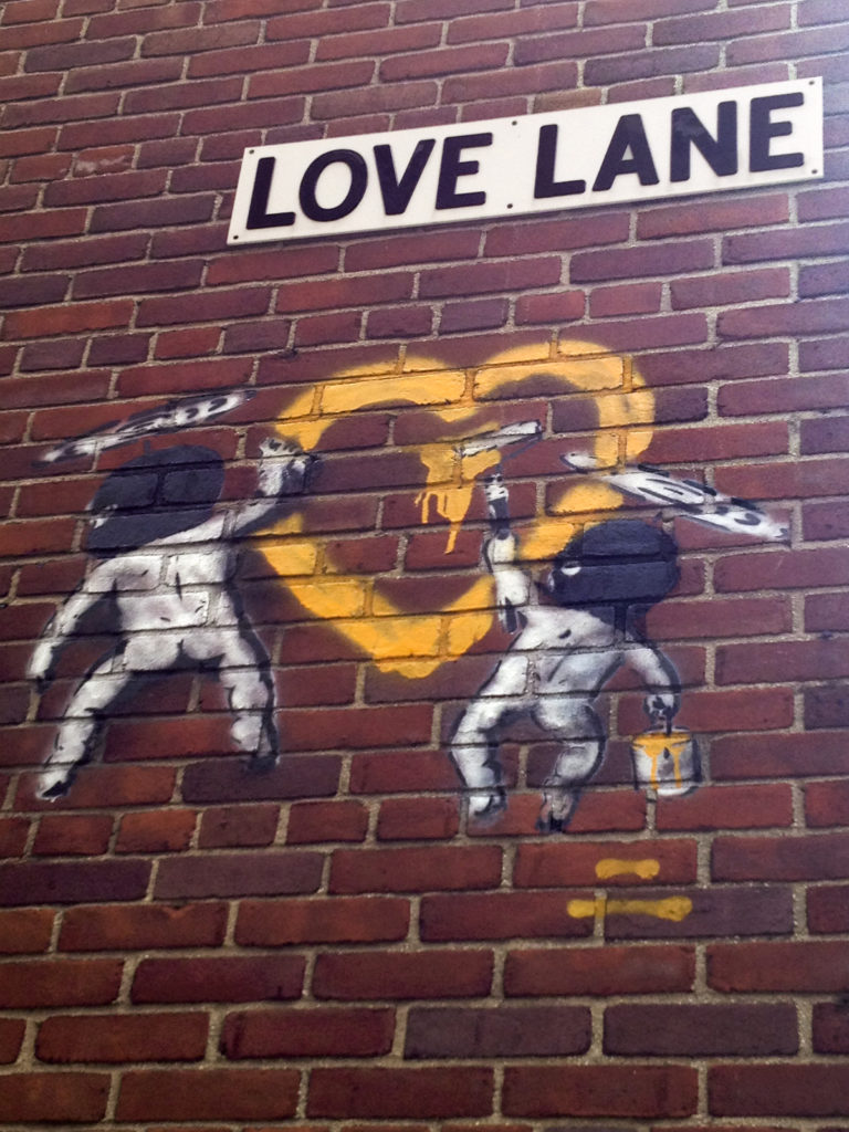 Rascally street Cupids surreptitiously graffiti a Valentine’s heart on a wall in Brooklyn Heights bearing the street name Love Lane. Eagle file photo by Lore Croghan