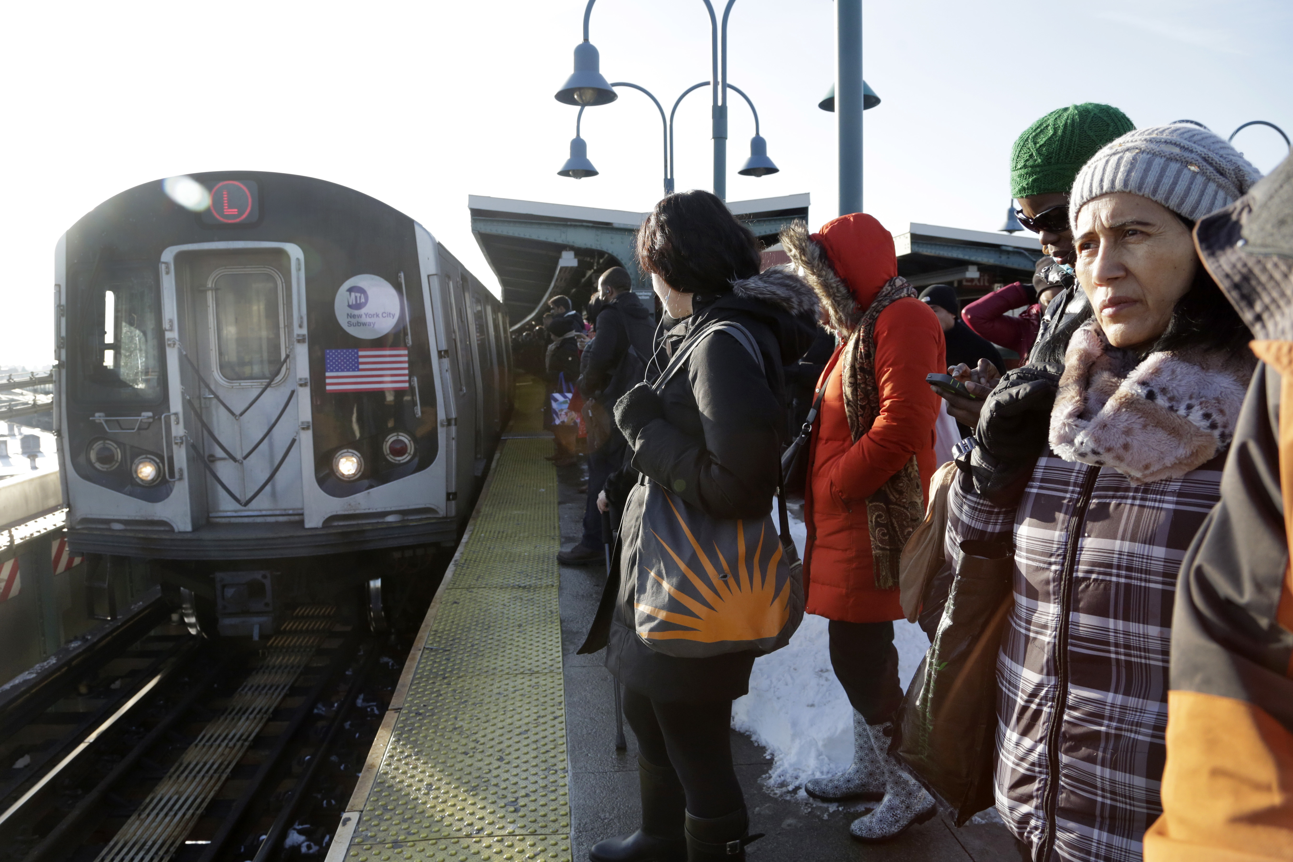 Commuters wait as an L train arrives at the Broadway Junction subway station in Brooklyn. AP Photo/Mark Lennihan, File