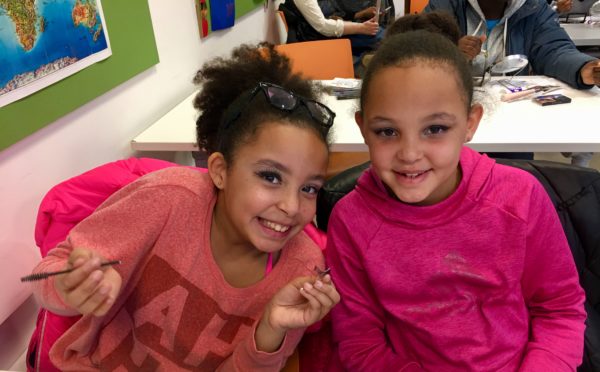 Young girls put on makeup for Brooklyn Public Library's Drag Queen Story Hour.