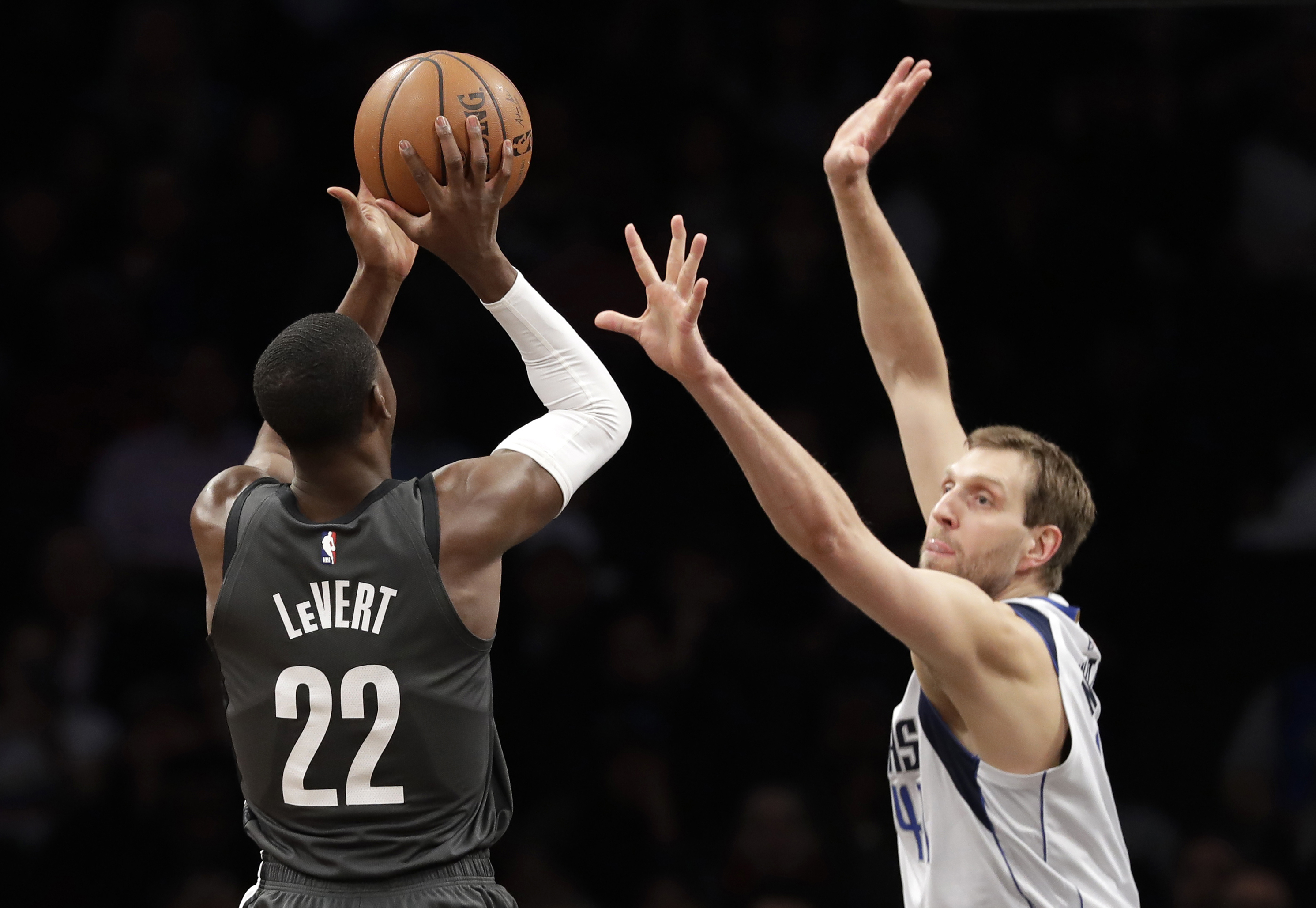 Dallas Mavericks forward Dirk Nowitzki right, defends Brooklyn Nets guard Caris LeVert (22) during the first half of Monday's game. AP Photos/Kathy Willens
