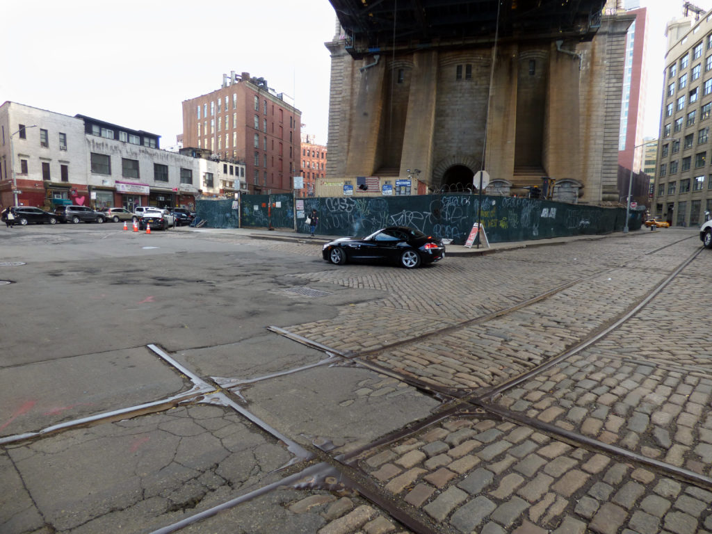 Tracks, brickwork and pavement beneath the Manhattan Bridge. Photo by Mary Frost.