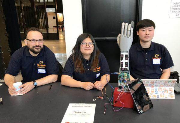 At the Mechatronics Competition at the Brooklyn Navy Yard on Monday, engineering students from City Tech put their projects through their paces before panels of judges. Above, from left: Lance Mercado, Yuzhen Li and Xiao Lin demonstrated the Smart Prosthetics arm that uses muscle sensors to control the artificial hand and fingers. Eagle photo by Mary Frost