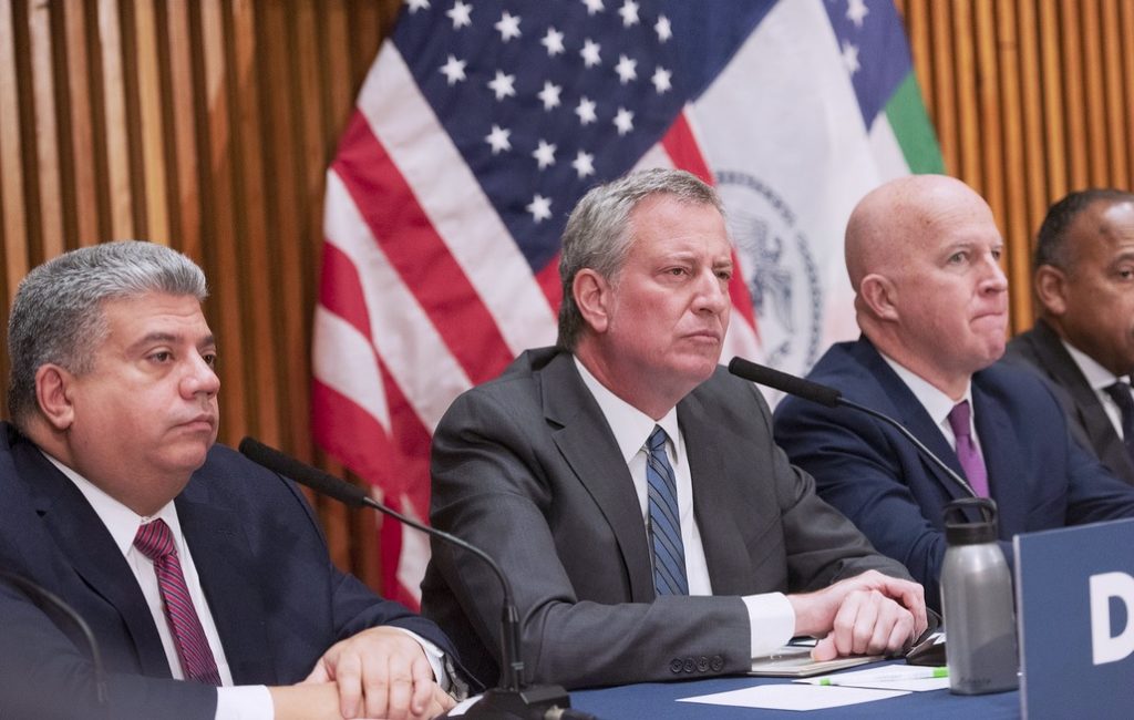 Crime in the city is down more than 10 percent so far this year, but murders have spiked in Brooklyn. Shown: Brooklyn District Attorney Eric Gonzalez, Mayor Bill de Blasio and Police Commissioner James O’Neill at Monday’s news conference. Photo by Michael Appleton, Mayor’s Office