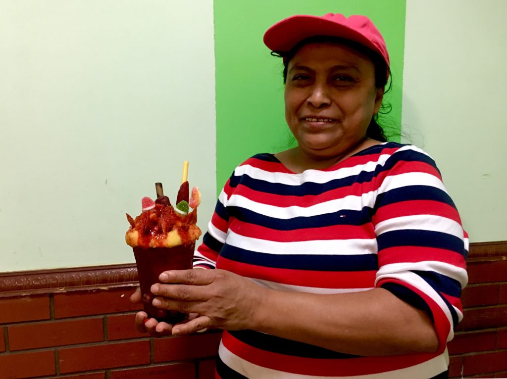 Soledad Chino of Nieves Tia Mimi holds a chamoyada, which is her Sunset Park shop’s top-selling treat. Eagle photo by Lore Croghan