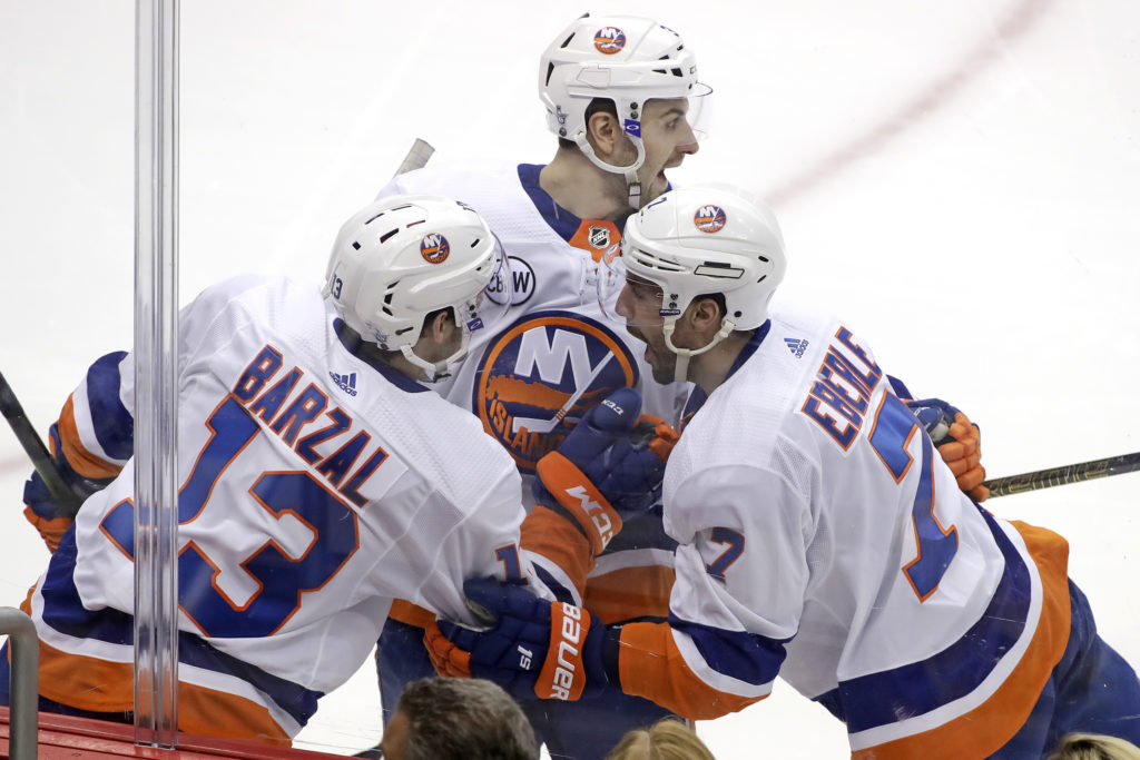 Mathew Barzal, Adam Pelech (center) and Jordan Eberle celebrate as the Islanders completed their first four-game playoff sweep since the 1983 Stanley Cup Finals against Edmonton Tuesday night in Pittsburgh. AP Photo/Gene J. Puskar