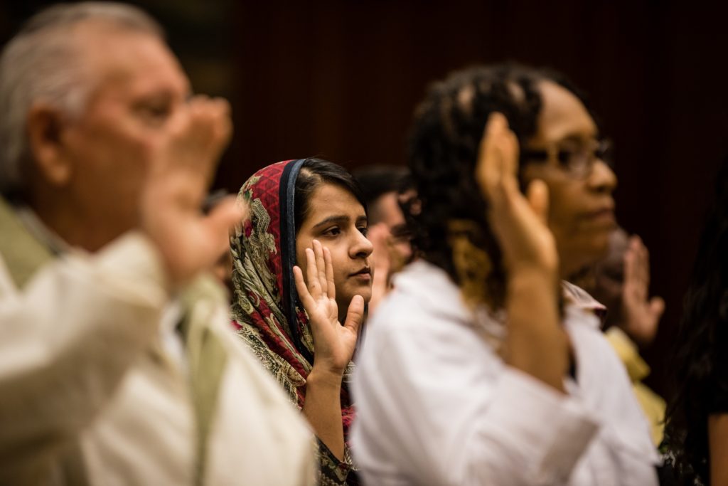 New U.S. citizens take the oath of loyalty at their naturalization ceremony. Eagle file photo by Paul Frangipane