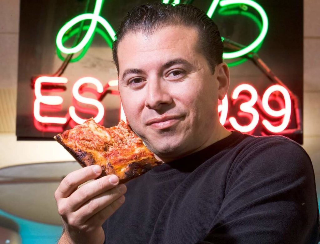 Tony Muia savoring a slice at L&B Spumoni Gardens. Photo courtesy of A Slice of Brooklyn Tours