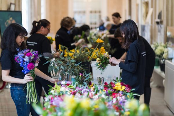 About two dozen volunteers fill a vestibule of Plymouth Church to make flower arrangements. Eagle photo by Paul Frangipane