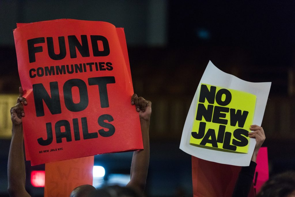 Members of No New Jails NYC hold up signs during an April 11 public hearing on the renovation of the Brooklyn Detention Complex. Eagle file photo by Paul Frangipane.