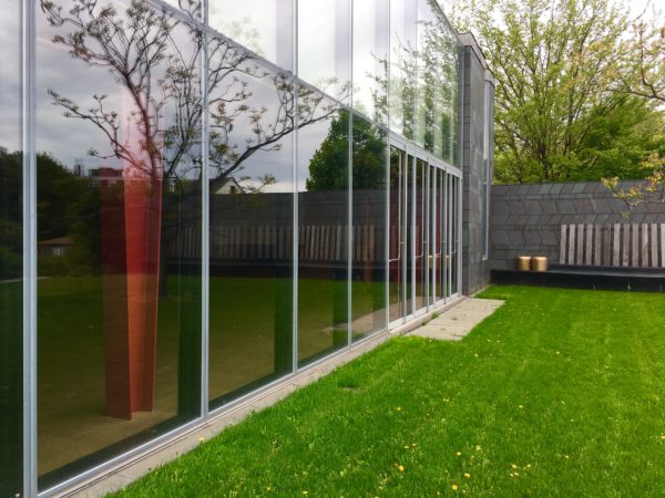 The Weeksville Heritage Center education and cultural arts building’s glass facade mirrors the scenery. Eagle photo by Lore Croghan