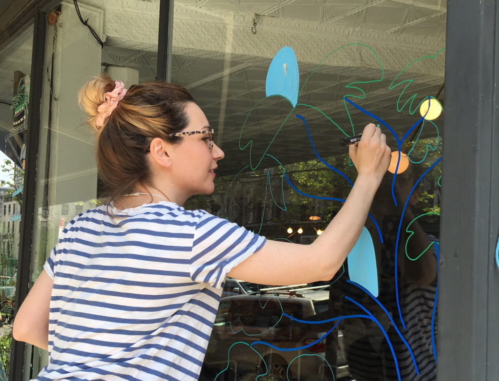 In preparation for ART360˚, artist Nina Summer paints the windows at GreeneGrape Annex. Photo via fabfulton