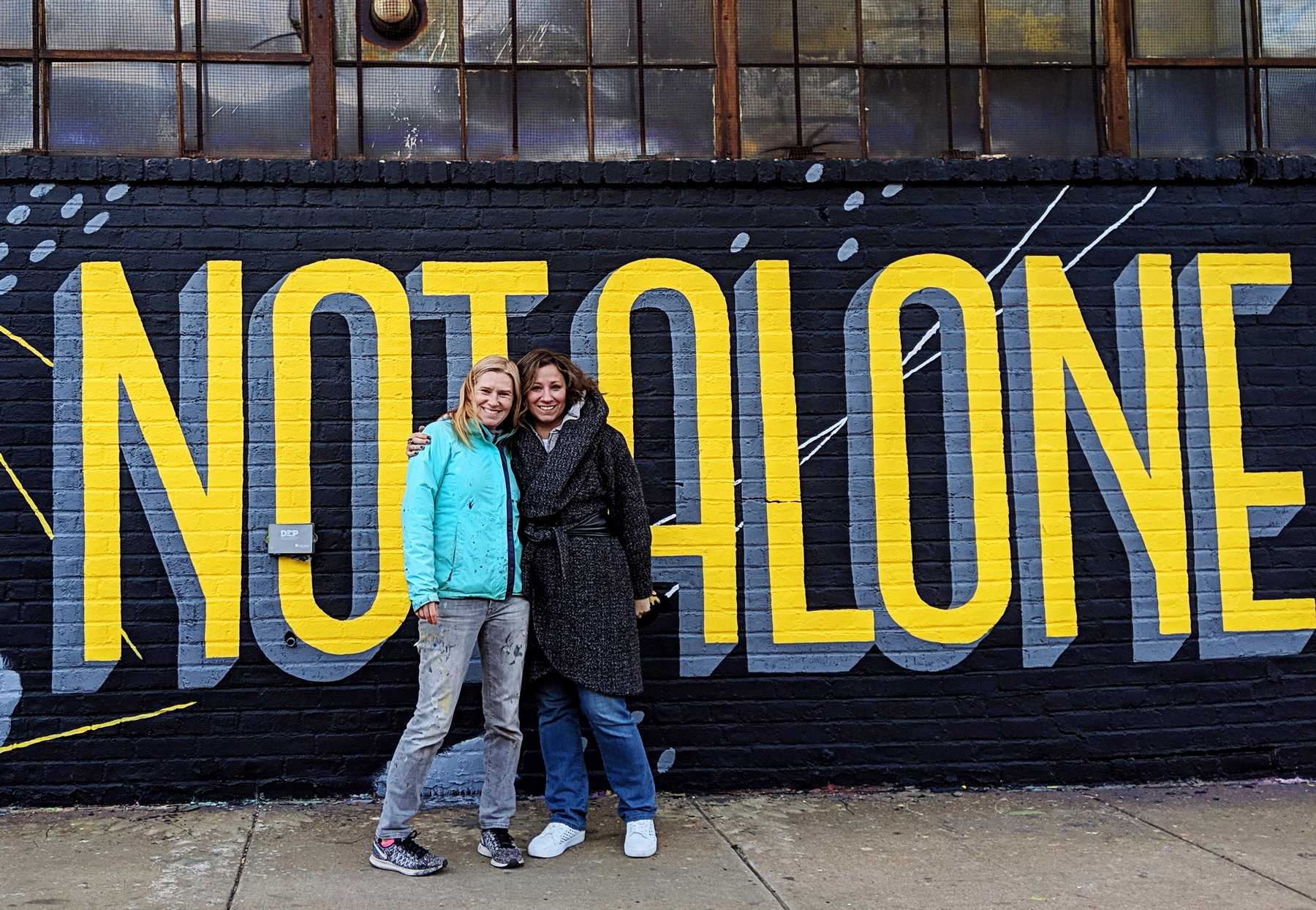Annica Lydenberg (left) and Samantha Schutz, who came up with the idea for the series of “You Are Not Alone” murals to mark Mental Health Awareness Month, are looking for more buildings to paint on. Photo by Jackson Cook