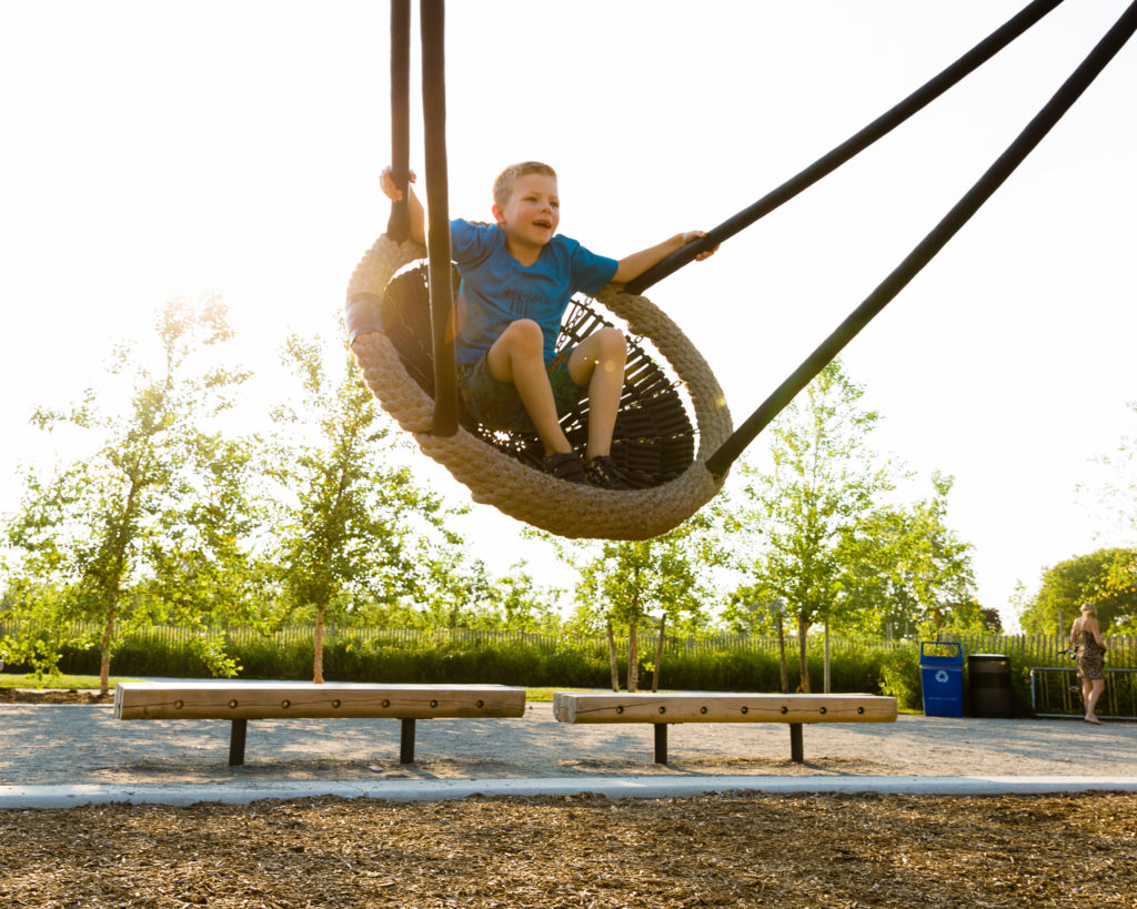 A child plays on a swing on Governors Island. Photo by Kreg Holt