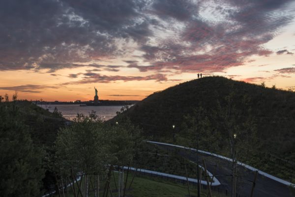 The sun sets behind the Statue of Liberty. Photo by Timothy Schenck