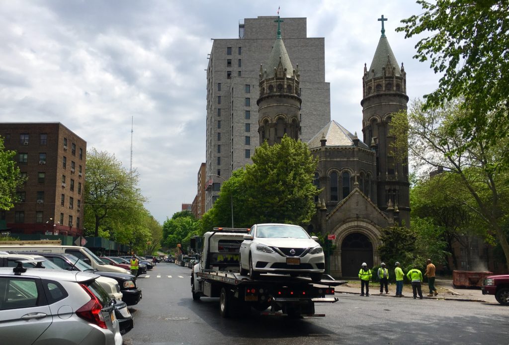 A tow truck lends a touch of urban drama to this view of the Church of St. Michael-St. Edward in Fort Greene. The tower behind it is 112 St. Edwards St. Eagle photo by Lore Croghan