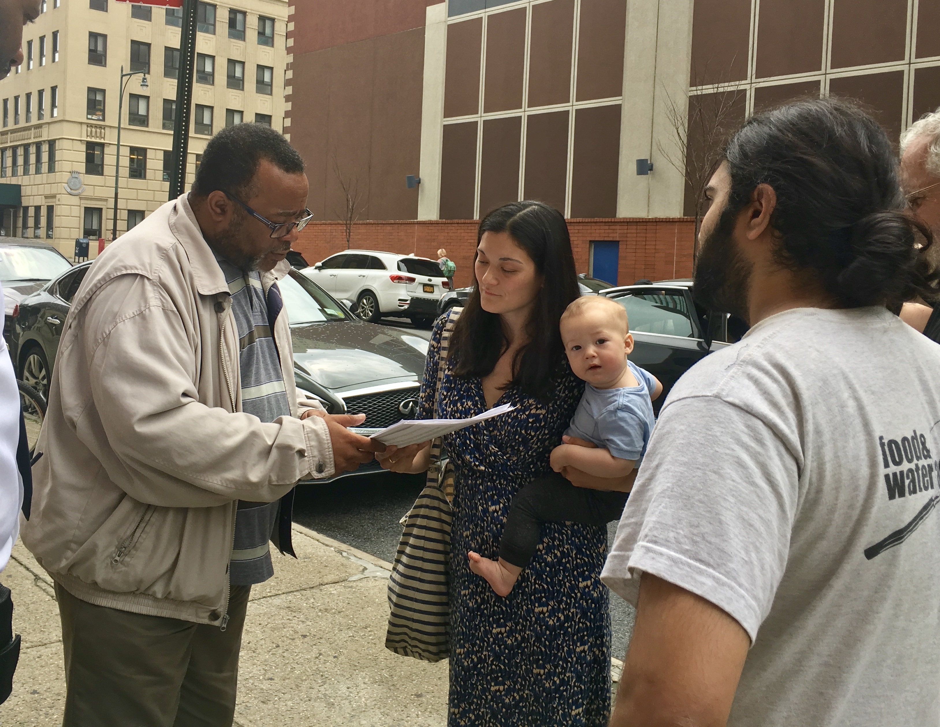 Nikki Crook, of 350 Brooklyn Parents, delivers petitions to a Jeffries staffer. Photo courtesy of Jenny Bock