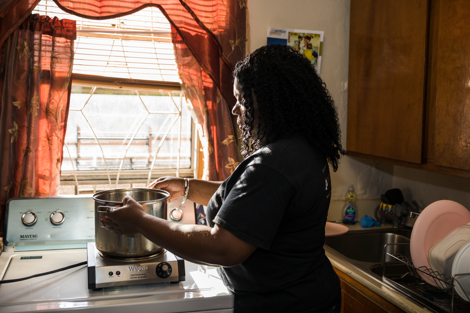 Sherry Roberson prepares to boil a pot of water on the hot plate NYCHA provided for her. She cooks for a four-person family. Eagle photo by Paul Frangipane