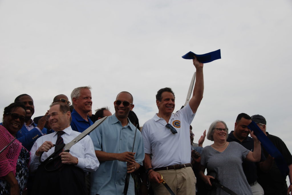 Gov. Andrew Cuomo (front, right) and U.S. Rep. Hakeem Jeffries (front, left) cut ribbon on Shirley Chisholm State Park opening. Eagle photo by Kelly Mena