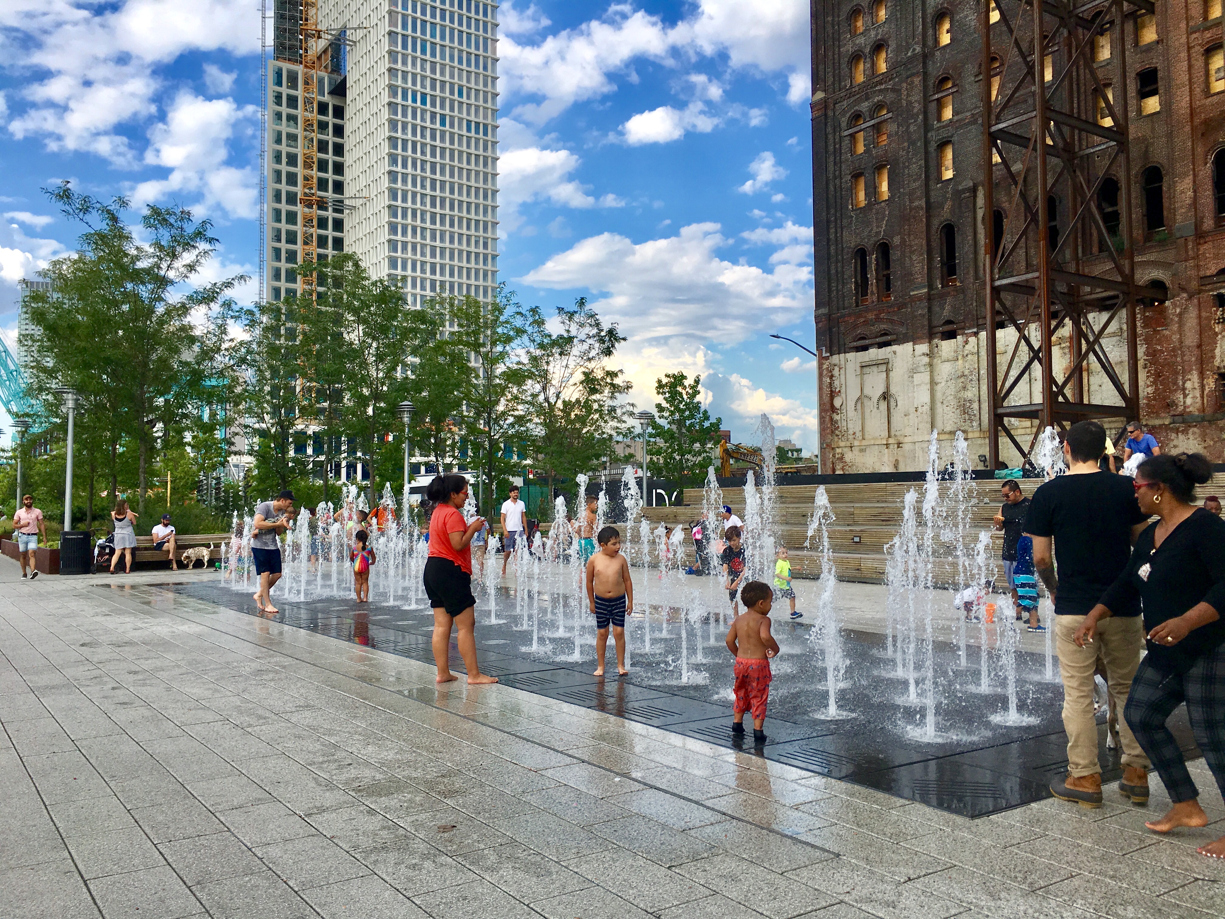 Kids are splish-splashing in Domino Park’s fountain. Eagle photo by Lore Croghan