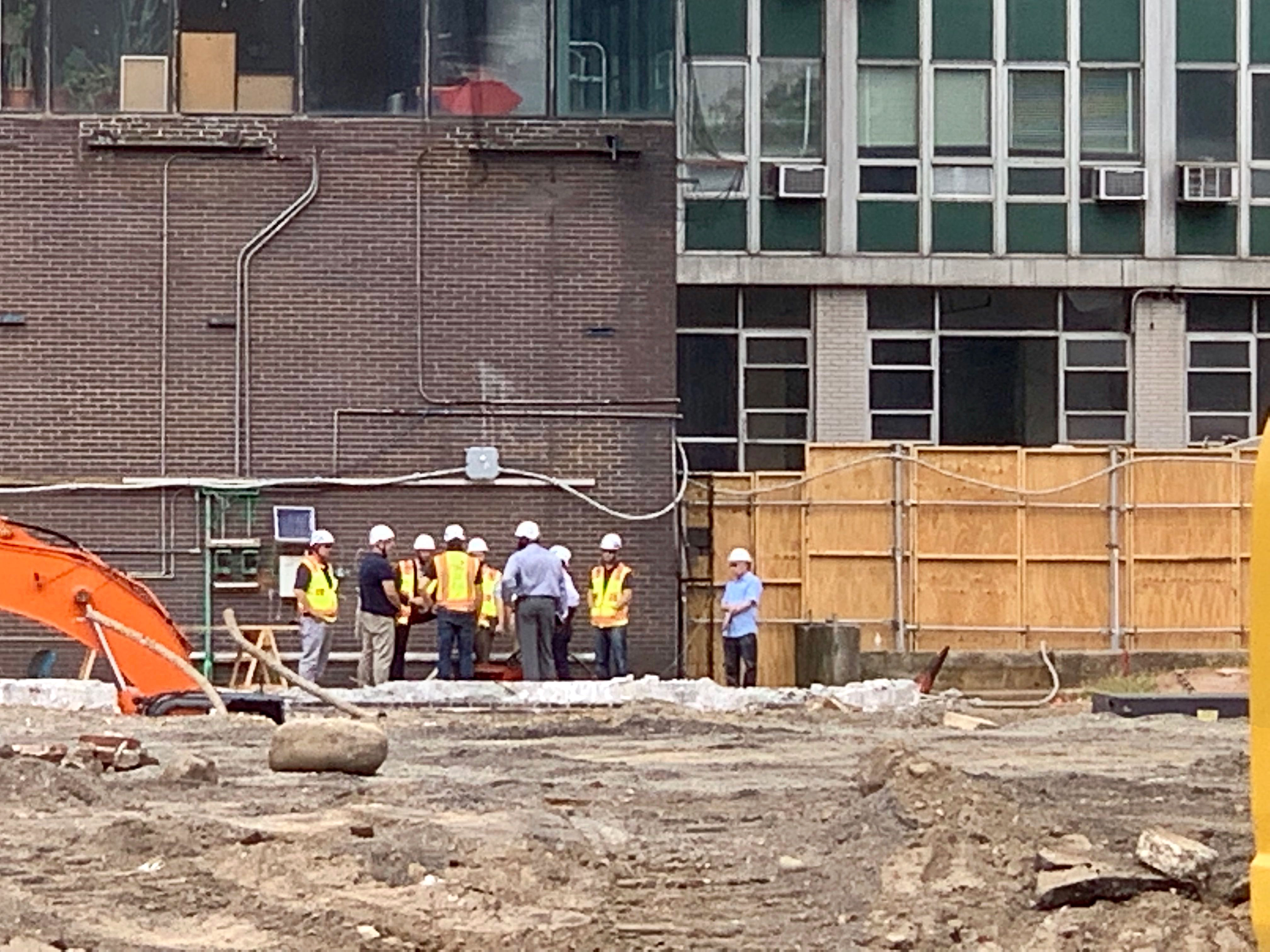 Inspectors gathered on Friday morning to discuss the damage at the site of Thursday’s explosion. Work on the 34-story building is halted. Eagle photo by Mary Frost