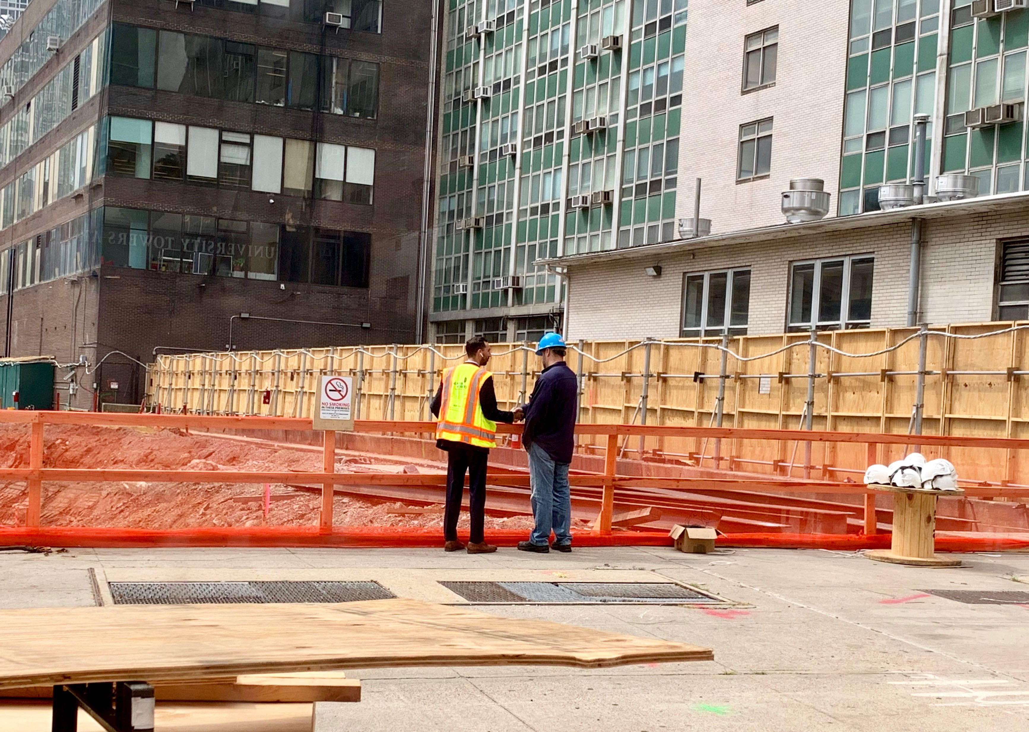 A worker at the site of Thursday’s electrical explosion greets an inspector from Con Edison on Friday morning. Eagle photo by Mary Frost