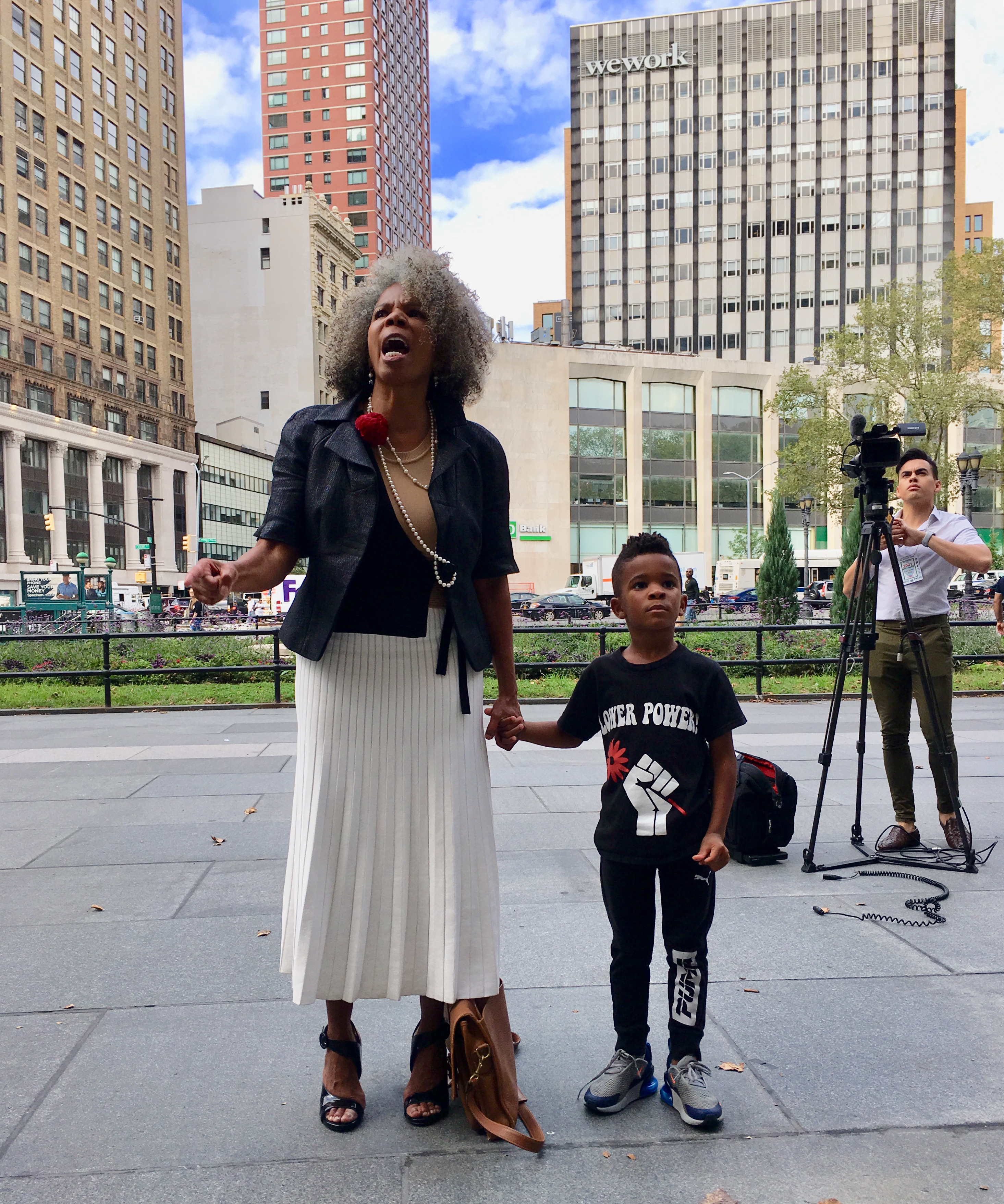 Activist Alicia Boyd, with her grandson Chase Omar Ricketts, addresses supporters outside Brooklyn Supreme Court. Eagle photo by Lore Croghan