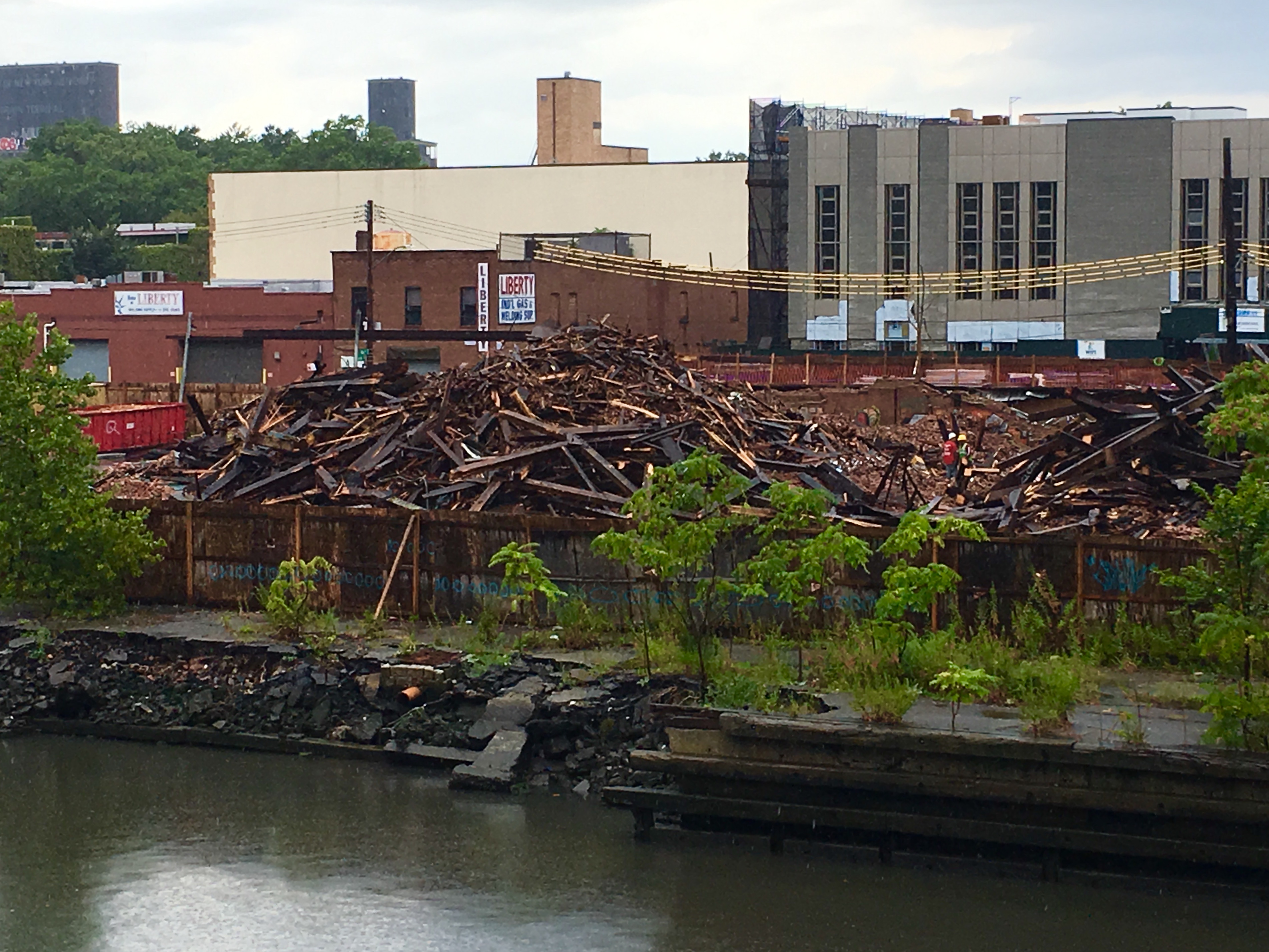 Rain-soaked timbers are piled up on the S.W. Bowne Grain Storehouse site. Eagle photo by Lore Croghan