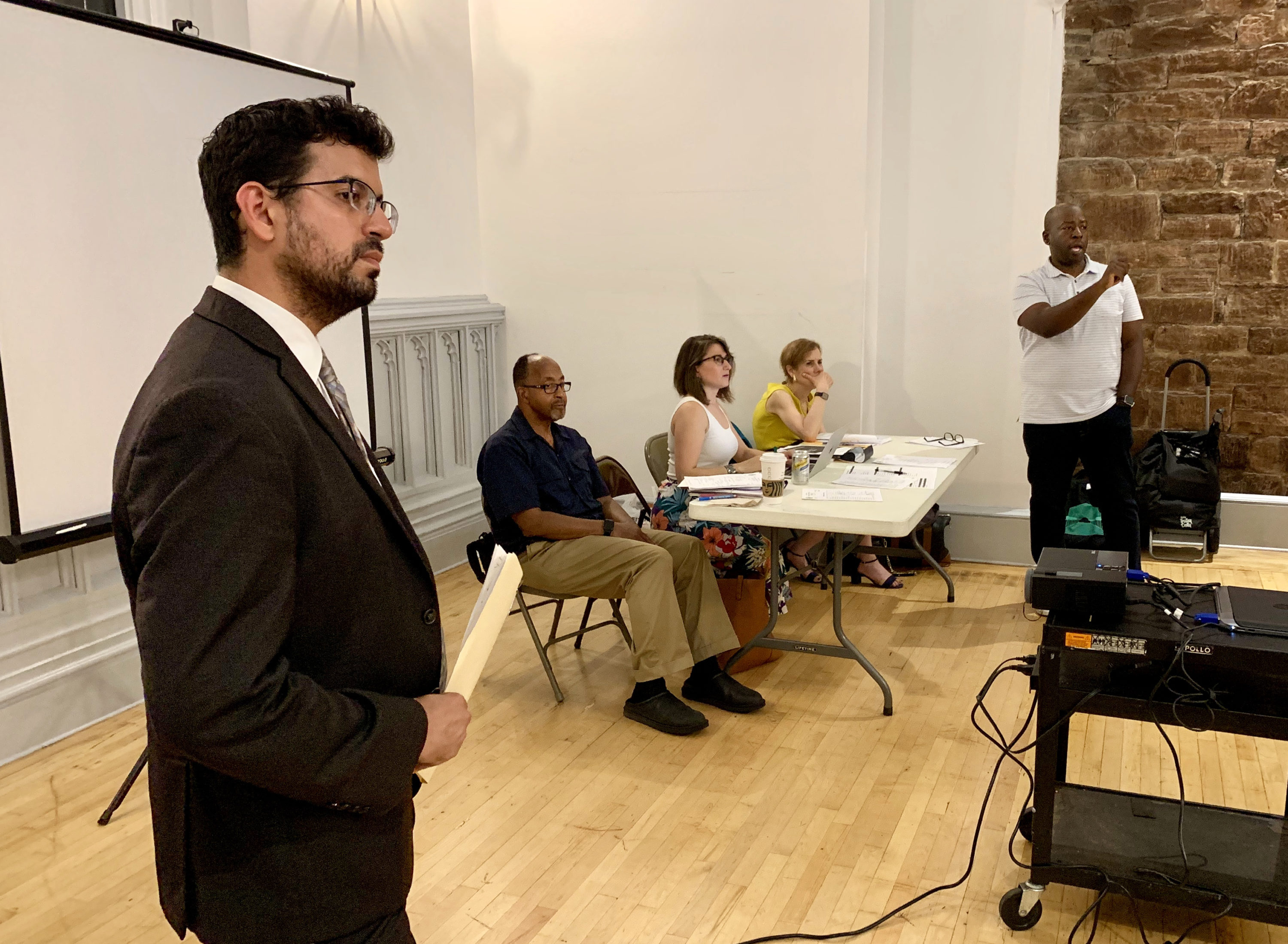 Glomani Bravo-Lopez, Councilmember Levin’s deputy chief of staff, asked the Community Board 2 board to hold off their vote on Willoughby Square Park for 30 days. In the back to the right is CB2 Chairperson Lenny Singletary. Eagle photo by Mary Frost.
