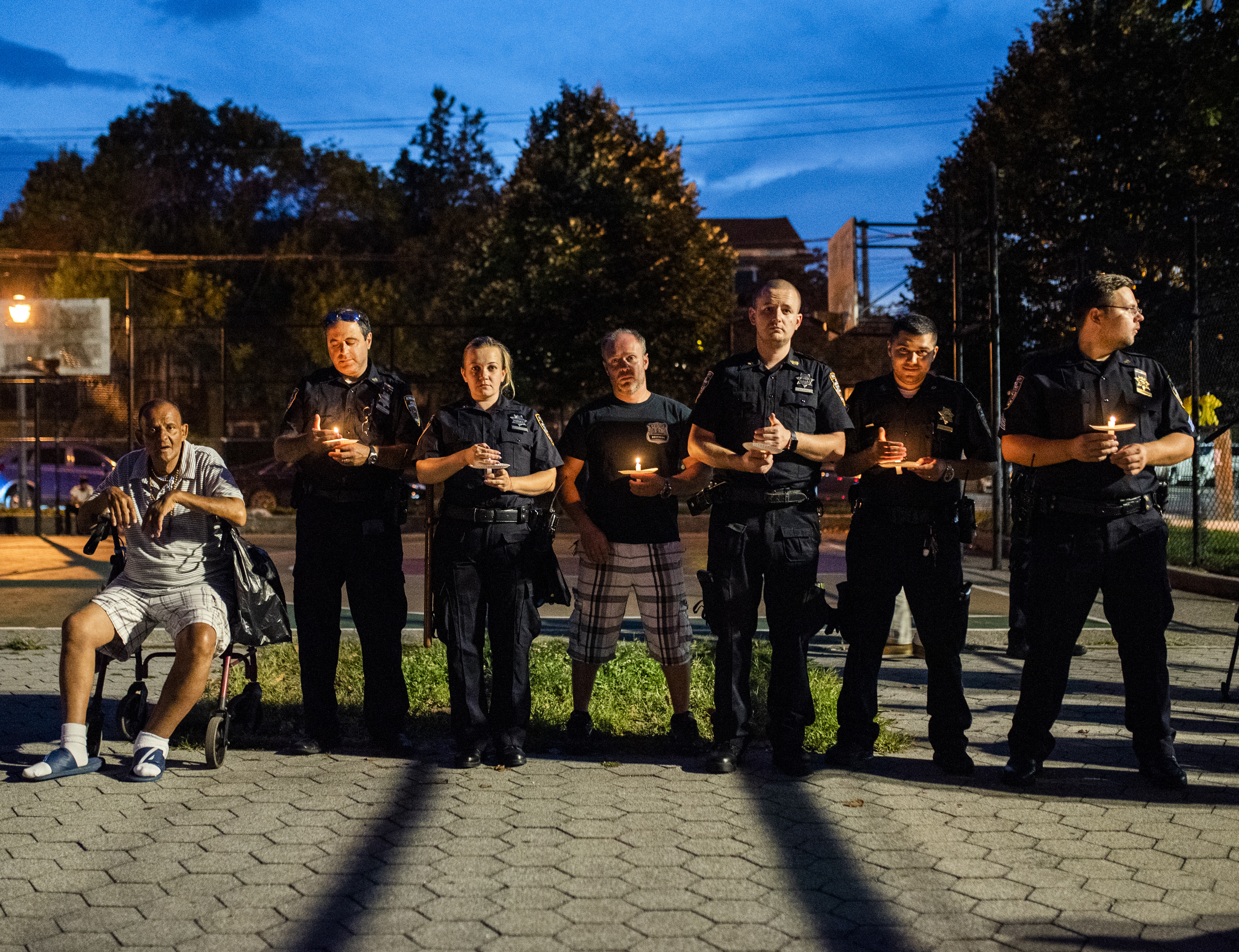 Police officers from the 61st Precinct hold candles at Bill Brown Playground’s 9/11 commemoration. Eagle photo by Mark Davis