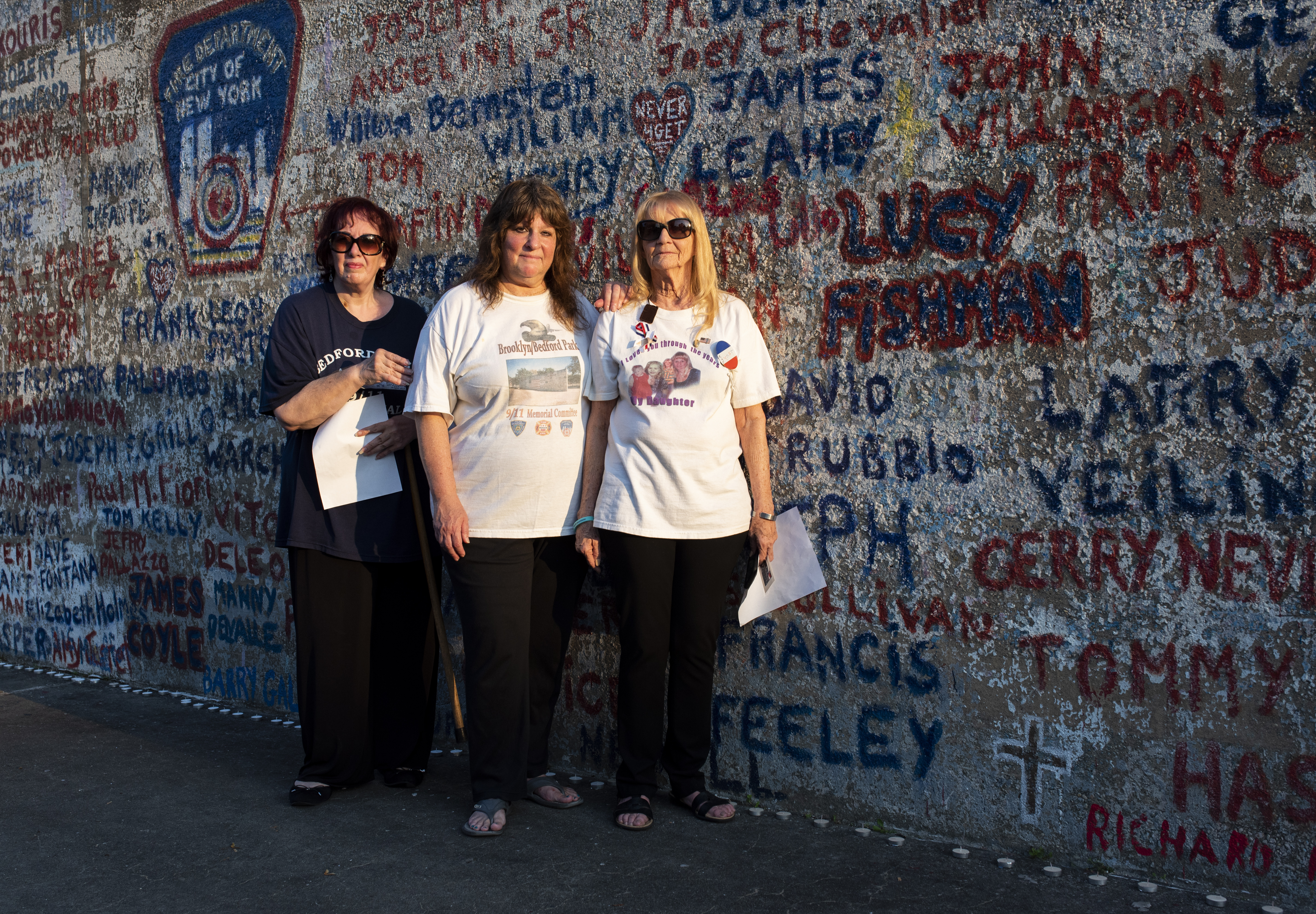 From left, 9/11 memorial organizers Angela Sabino, Tina Gray and Mary Bracken, who’s standing next to her daughter Lucy Fishman’s name painted on the wall. Eagle photo by Mark Davis