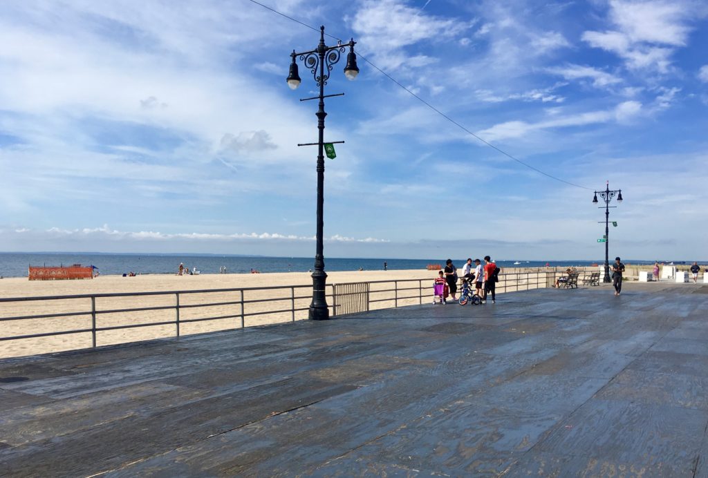 Old-fashioned street lamps rise above the Coney Island Boardwalk’s plywood cover. Eagle photo by Lore Croghan