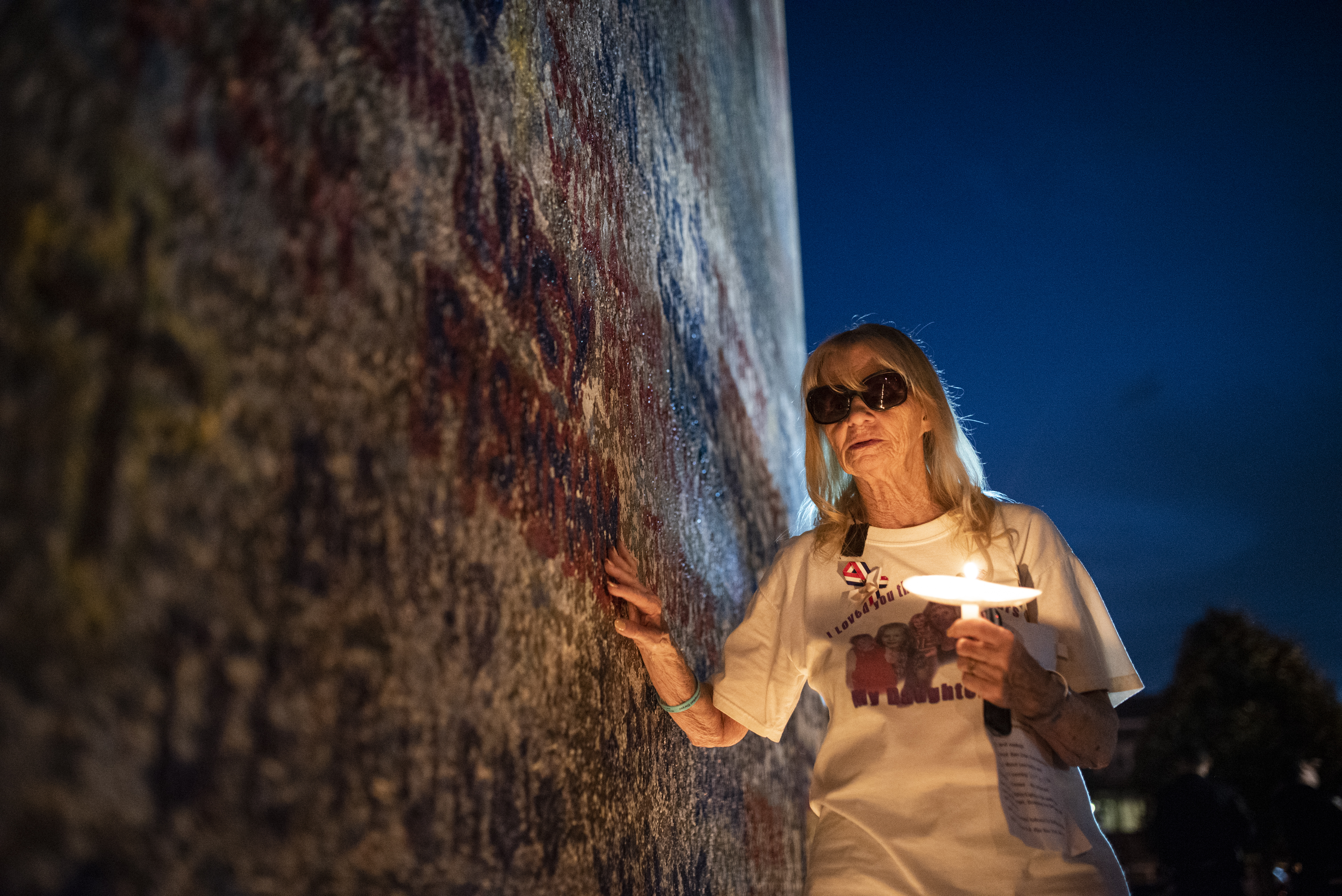 Mary Bracken touches her daughter Lucy Fishman’s name on Sheepshead Bay’s 9/11 memorial wall. Eagle photo by Mark Davis