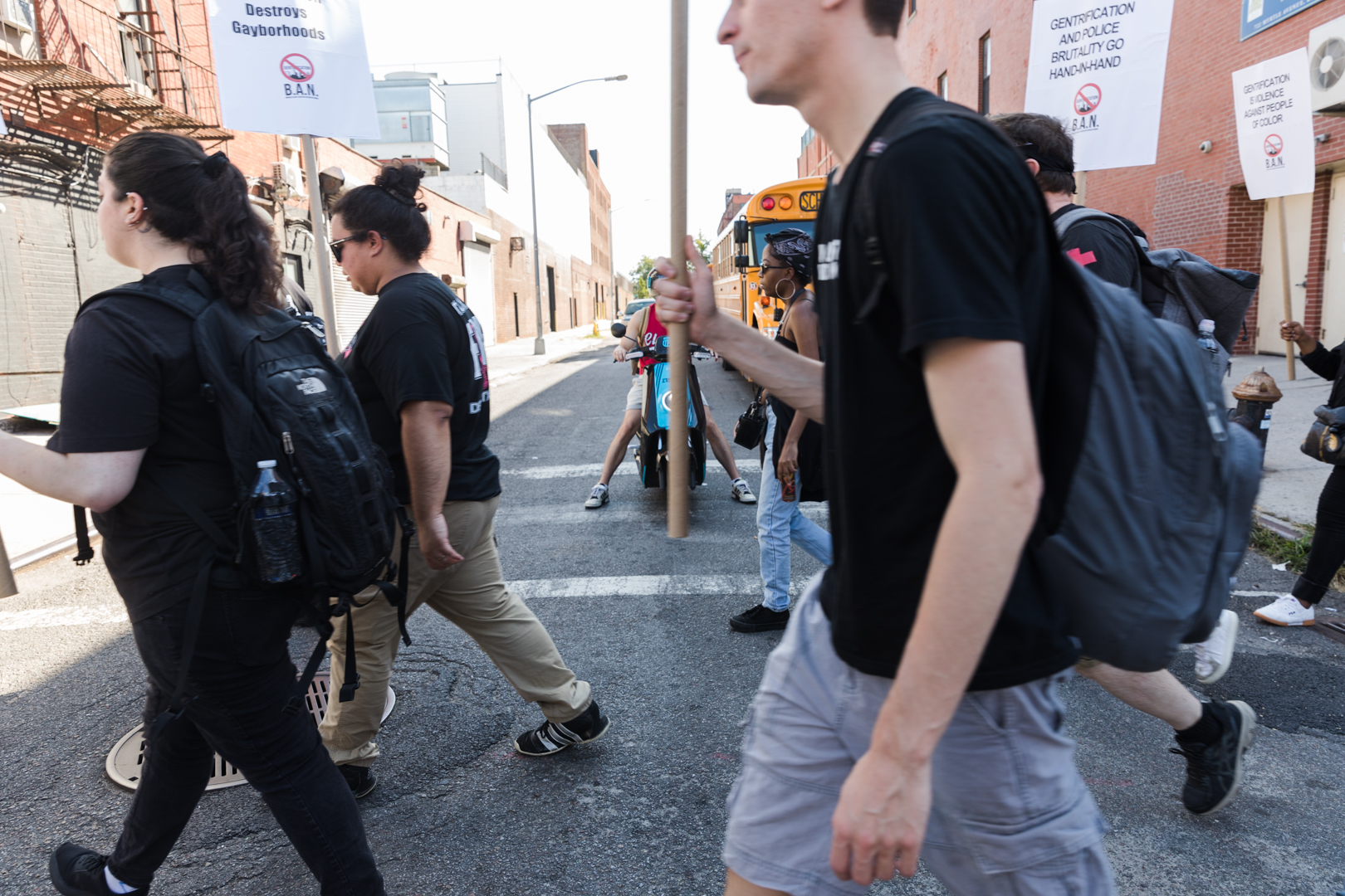Marchers pass signs of Brooklyn’s gentrification. Eagle photo by Paul Frangipane