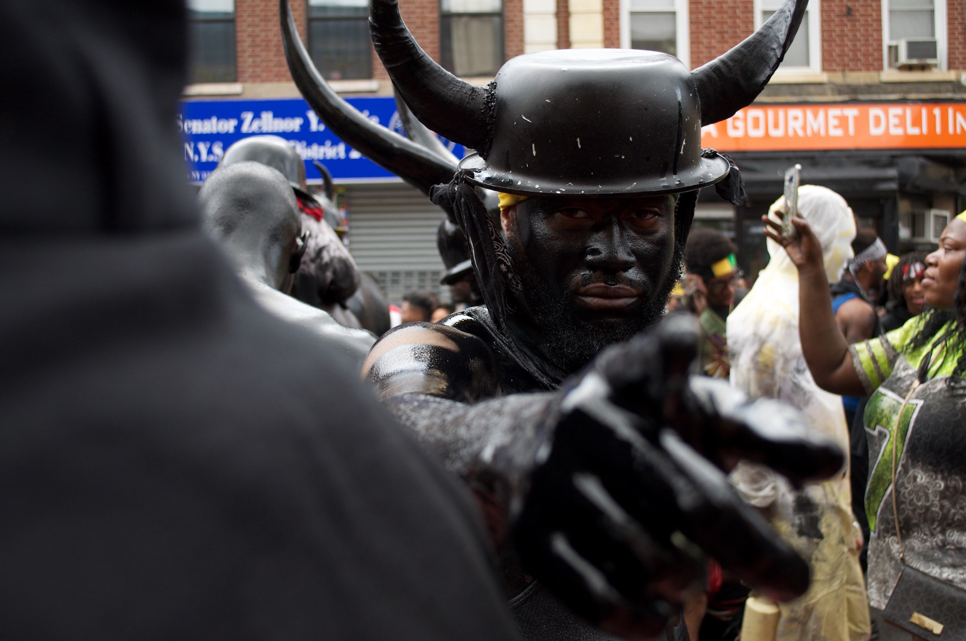 An attendee covered in oil wearing a hat with horns.